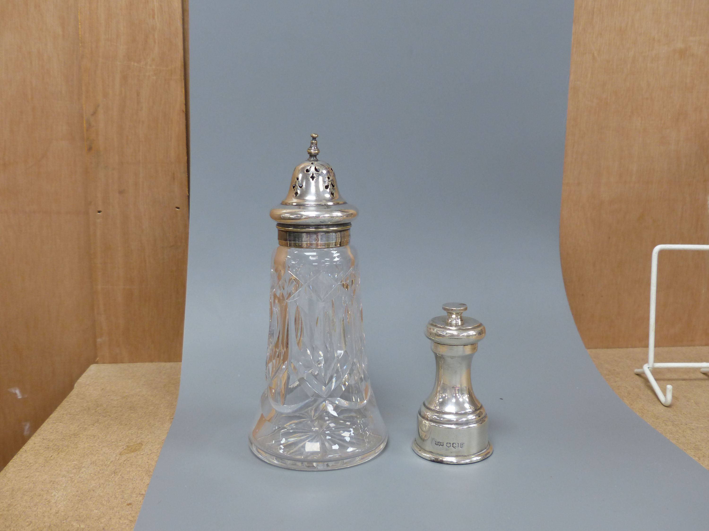 A modern silver pepper mill, Mappin & Web, Sheffield, 1957, 85mm and silver plated mounted glass sugar sifter.